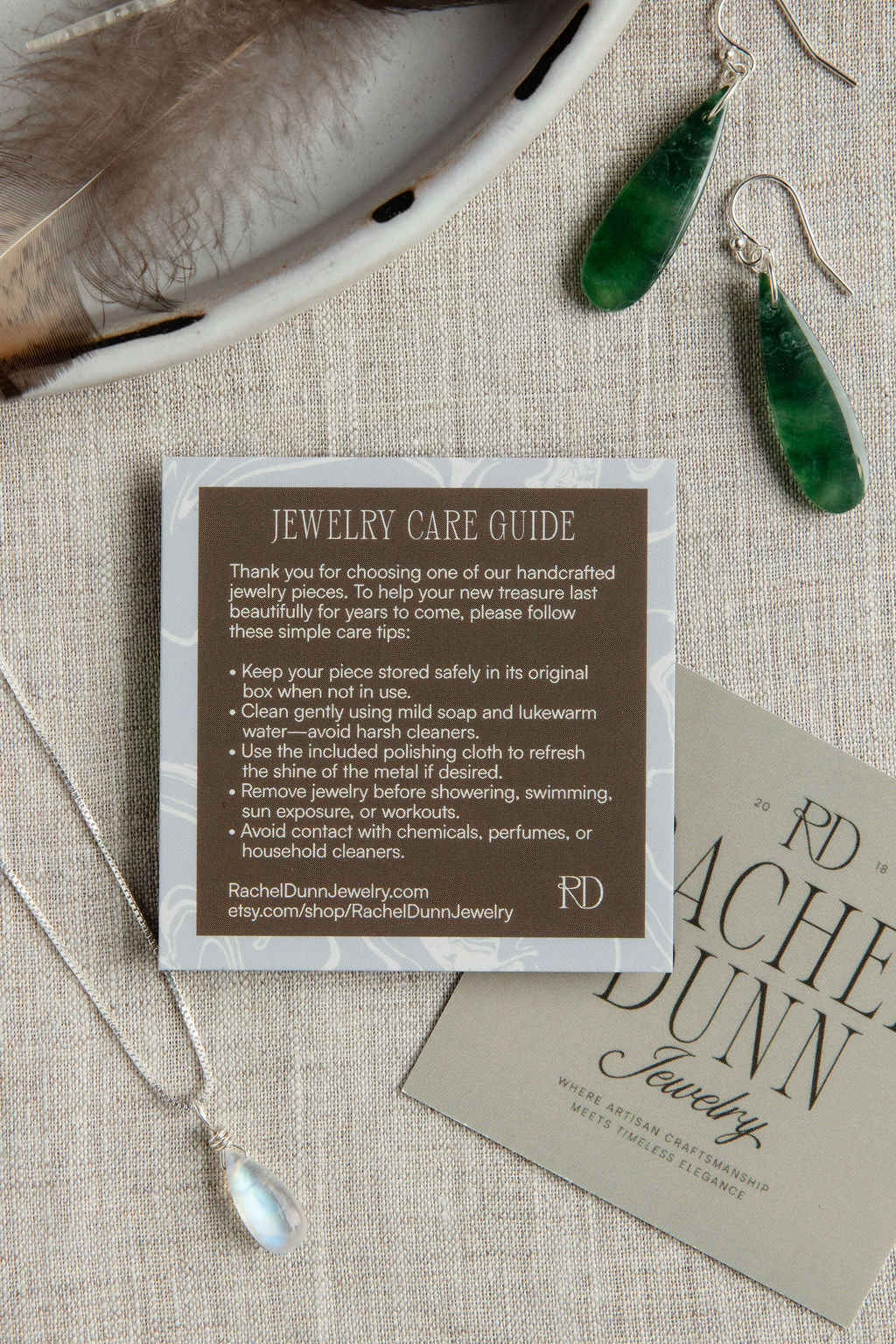 Jewelry care guide card with green earrings and necklace on a textured surface