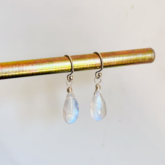 A pair of handcrafted Moonstone teardrop dangle earrings made from solid sterling silver, showing the brilliant blue flash of the natural gemstones.
