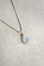 Load image into Gallery viewer, Necklace with a teardrop-shaped moonstone pendant on a light fabric background

